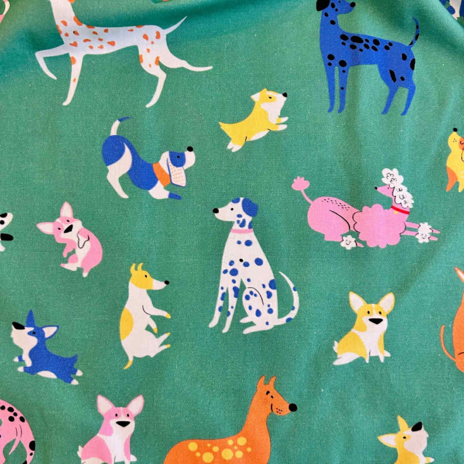 Pattern of colorful dogs on a green background