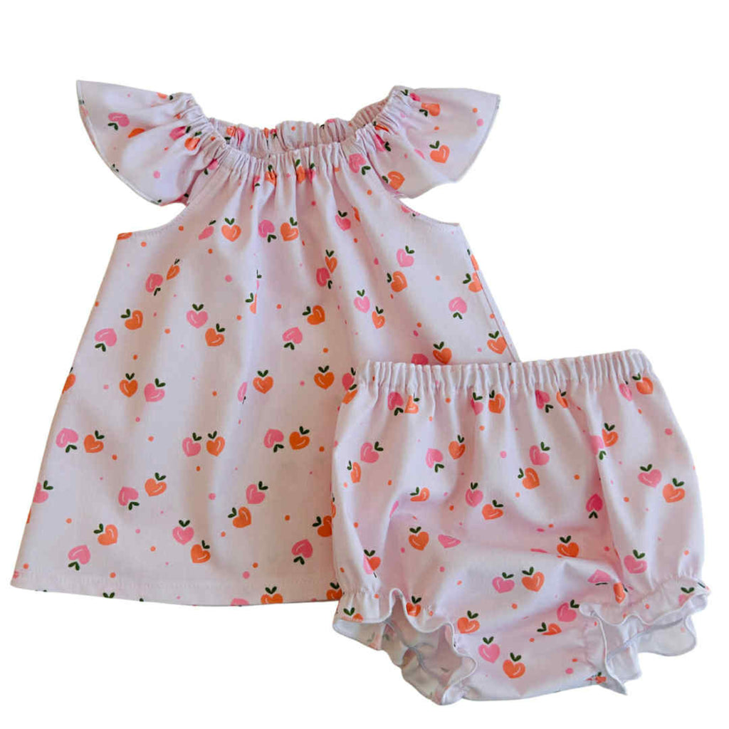 Baby dress and bloomers with apple pattern on a white background