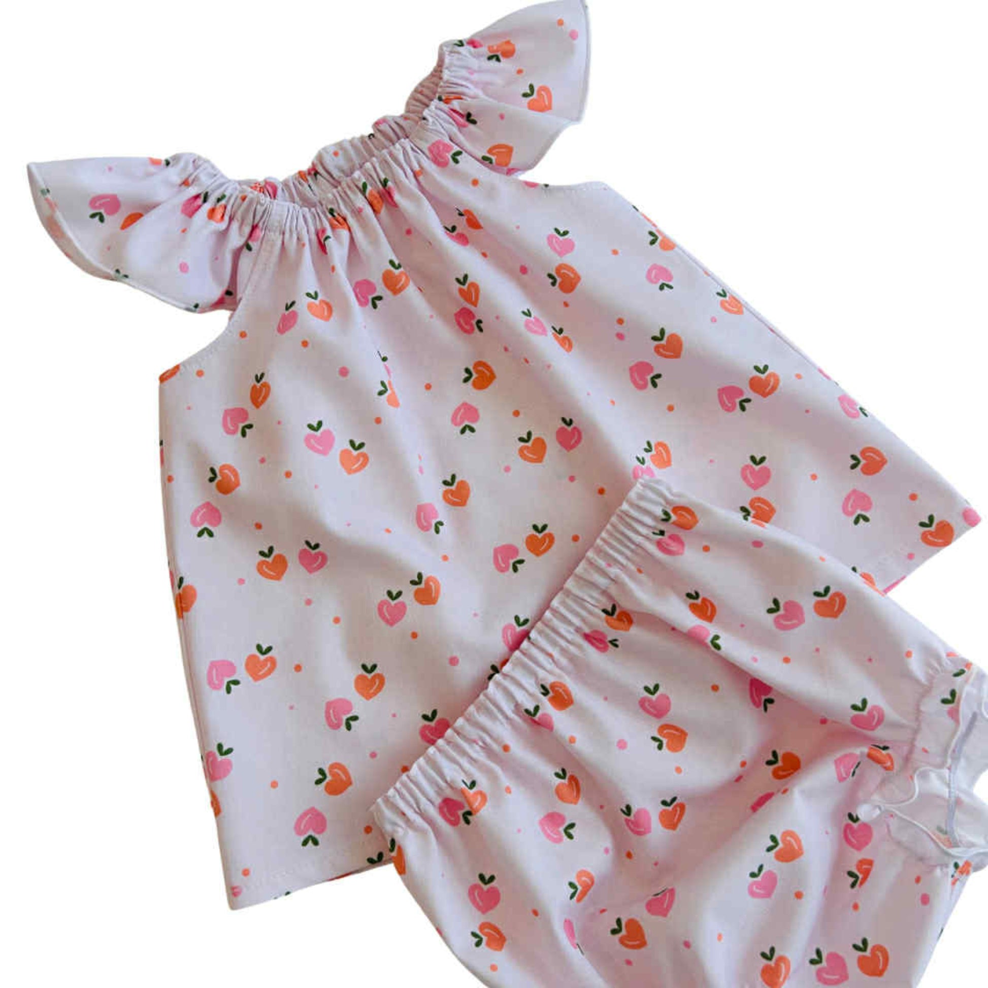 Baby dress with strawberry pattern on a white background