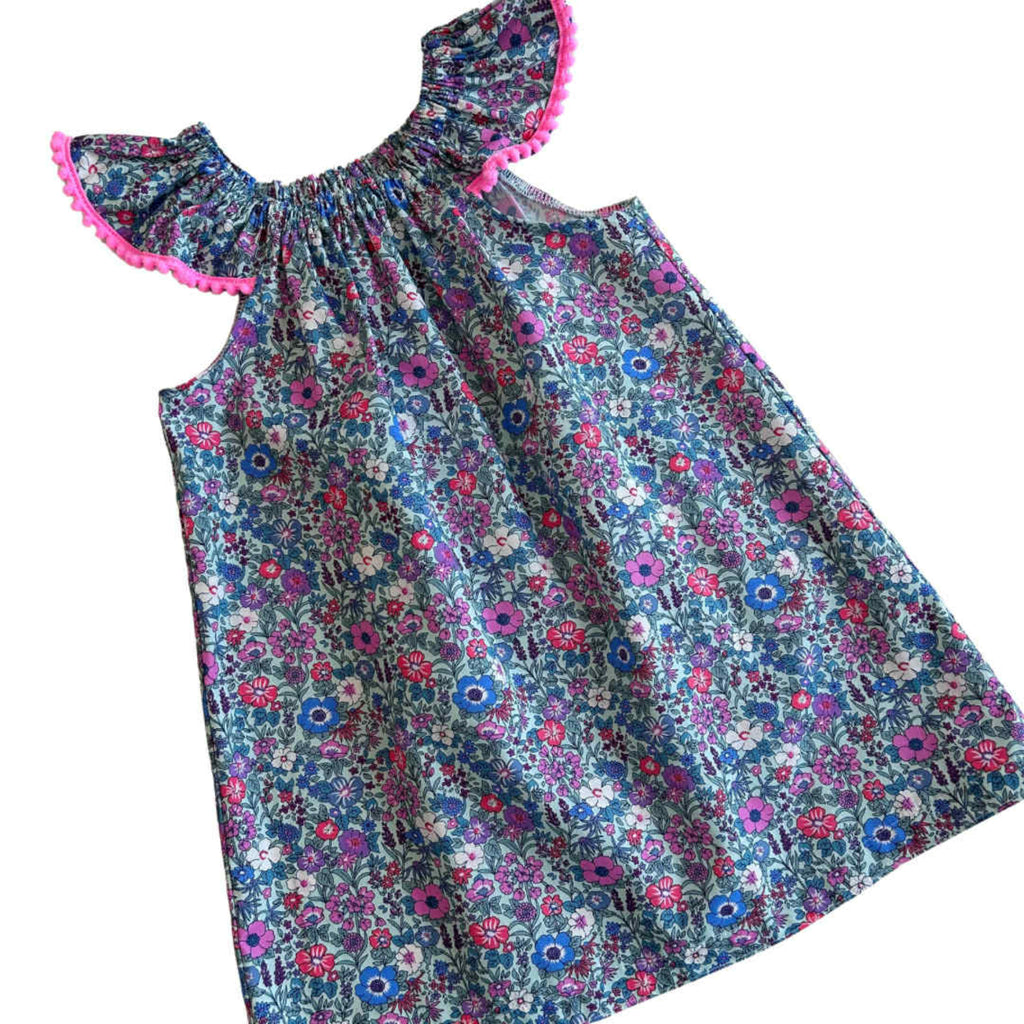 Floral dress with pink pom pom trim and flutter sleeves
